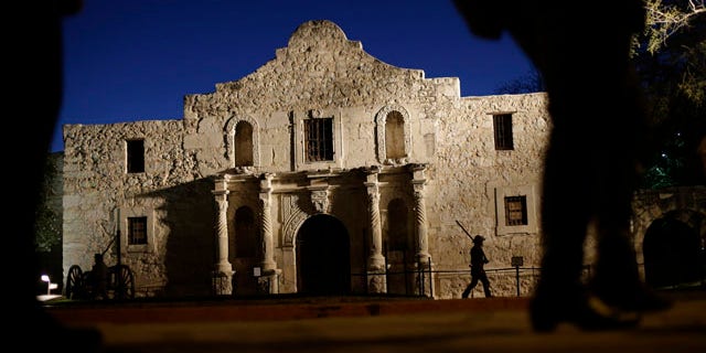 File - In this March 6, 2013, file photo, Dan Phillips, a member of the San Antonio Living History Association, patrols the Alamo during a pre-dawn memorial ceremony to remember the 1836 Battle of the Alamo and those who fell on both sides. (AP Photo/Eric Gay, File)