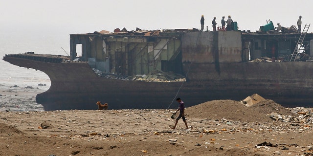Workers take apart a decommissioned ship at the Alang shipyard in the western Indian state of Gujarat. Steel from ship salvage provides 10 percent of the nation's annual requirements.