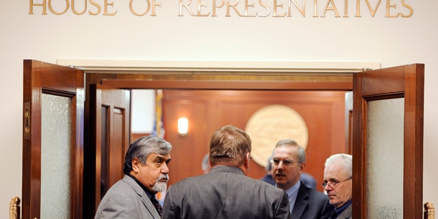 April 17: From left Rep. Bill Thomas, R-Haines, Rep. Bill Stoltze, R-Chugiak, Rep. Bryce Edgmon, D-Dillingham, and Rep. Bob Herron, D-Bethel, talk in the entry way to House chamber following a recess of the House on the last day of regular session in Juneau, Alaska.