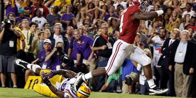 Nov. 3, 2012: Alabama running back T.J. Yeldon (4) runs over LSU defensive end Barkevious Mingo (49) for the go ahead touchdown to beat LSU 21-17 during the second half of an NCAA college football game.
