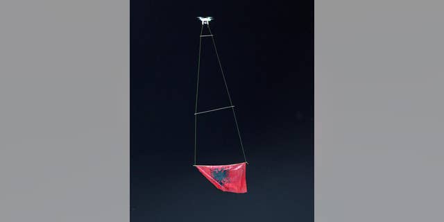 A drone flies an Albanian flag at the national league match in Vlora, 140 kilometers (85 miles) southwest of capital Tirana, between local Flamurtari FC vs. KF Skenderbeu, Friday, Oct. 17, 2014. The game ended 1-1. Earlier this week a drone that flew an Albanian nationalist banner over a soccer stadium in Belgrade, Serbia ignited a brawl when Albanian players who tried to protect it were attacked by Serb counterparts, fans and security staff on the pitch, forcing the referee to abandon the match. (AP Photo/str)