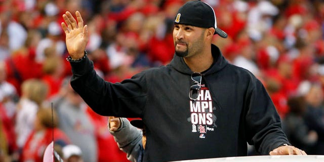 St. Louis Cardinals' Albert Pujols waves to fans at Busch Stadium during a victory parade in celebration of the Cardinals' 11th World Series victory, Sunday, Oct. 30, 2011, in St. Louis. The free agent has reportedly been wooed by the Cardinals and the Marlins. (AP Photo/Jeff Roberson)