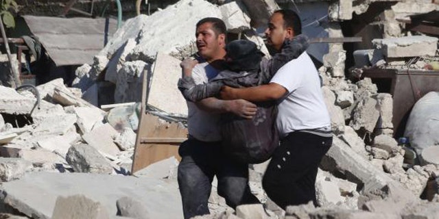 August 11, 2014: Men carry a wounded woman at a site hit by what activists said was a missile fired by forces loyal to Syria's President Bashar al-Assad at Aleppo's Bab al-Nairab district. (REUTERS/Rami Zayat)