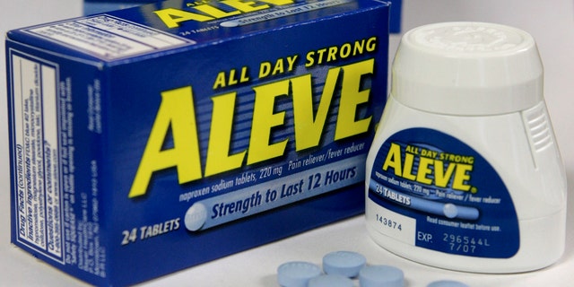 Several Aleve tablets appear in front of bottles of the pain reliever. (AP Photo/Steven Senne, File)