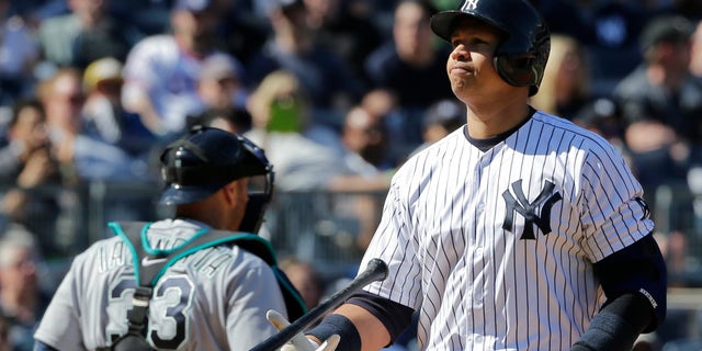 New York Yankees' Alex Rodriguez flips his bat after striking out during the sixth inning of a baseball game as Seattle Mariners catcher Chris Iannetta (33) walks toward the dugout Saturday, April 16, 2016, in New York. (AP Photo/Frank Franklin II)