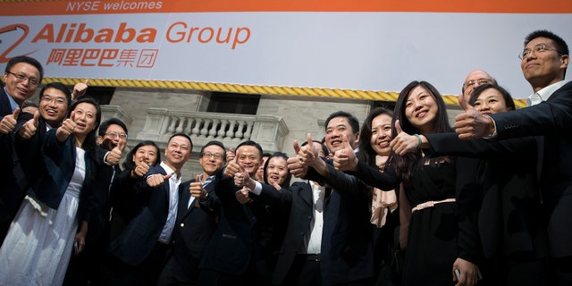 Alibaba Group Holding Ltd founder Jack Ma (C) and Joseph Tsai (center L), vice chairman and co-founder, pose with employees as they arrive for the company's initial public offering (IPO) under the ticker 'BABA,' at the New York Stock Exchange Sept. 19.