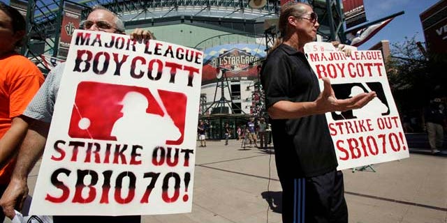 Raul Cordero, left, and Jorge Mandez protest Arizona's immigration law SB1070 outside of Chase Field before the Home Run Derby for the MLB All-Star baseball game Monday, July 11, 2011, in Phoenix. (AP Photo/Matt York)