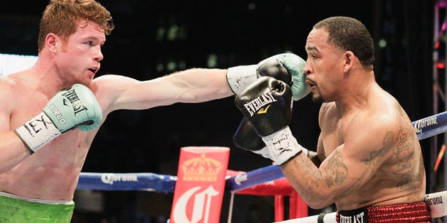 Saul "Canelo" Alvarez, left, lands a a jab to the face of James Kirkland during a 154-pound fight on Saturday, May 9, 2015, in Houston. Alvarez won the bout. (AP Photo/Bob Levey)