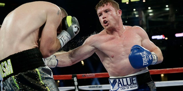 Canelo Alvarez, right, punches Liam Smith, left, during the fifth round of the WBO Junior Middleweight championship boxing match at the stadium in Arlington, Texas, Saturday, Sept. 17, 2016. Alvarez won by a knock out in the ninth round. (AP Photo/LM Otero)