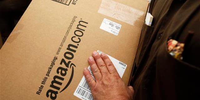 In this Oct. 18, 2010 file photo, an Amazon.com package is prepared for shipment by a United Parcel Service driver in Palo Alto, Calif.