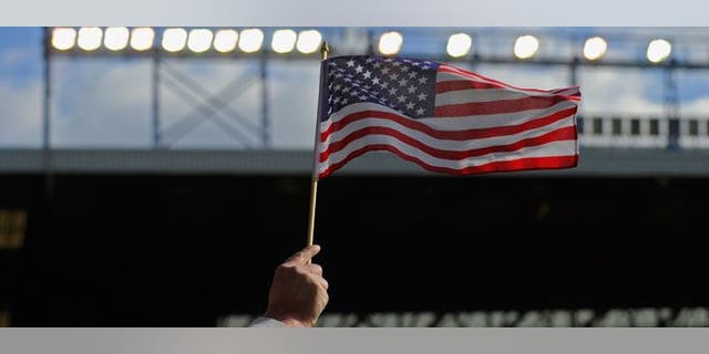LIVERPOOL, ENGLAND - OCTOBER 17: An Everton fan waves an American flag during the Barclays Premier League match between Everton and Liverpool at Goodison Park on October 17, 2010 in Liverpool, England. (Photo by Michael Regan/Getty Images)