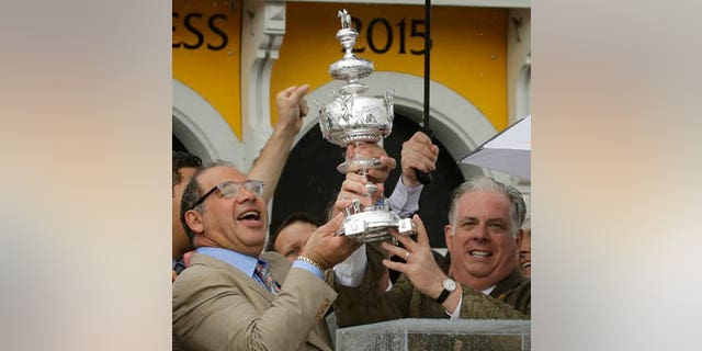 May 16, 2015: American Pharoah owner Ahmed Zayat, left, and Maryland Gov. Larry Hogan hold the Woodlawn Vase after American Pharoah with Victor Espinoza aboard won the 140th Preakness Stakes horse race at Pimlico Race Course in Baltimore. (AP Photo/Matt Slocum, File)