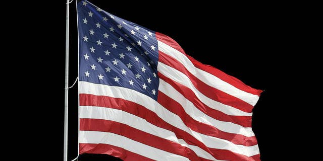 The American flag flies at the entrance to a Ford auto dealership Friday, July 1, 2005 in Wickliffe, Ohio. (AP Photo/Tony Dejak)