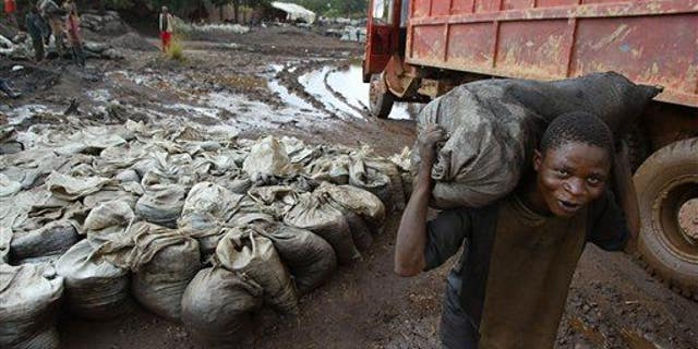 In this April 10, 2004, file photo, a young man carries wet cobalt on his back at the Shinkolobwe cobalt mine in the Democratic Republic of Congo.