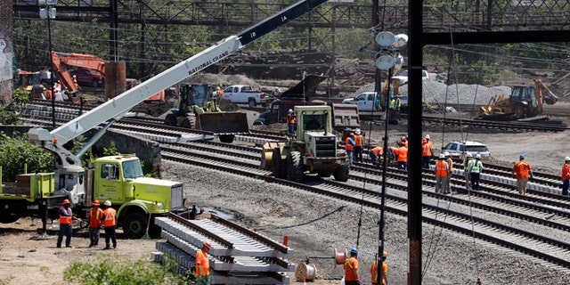 Workers labor on the site where a deadly train derailment occurred earlier in the week, Friday, May 15, 2015, in Philadelphia. Amtrak is working to restore Northeast Corridor rail service between New York City and Philadelphia. Service was suspended after a train derailed in Philadelphia on Tuesday night, killing eight passengers and injuring more than 200. (AP Photo/Julio Cortez)