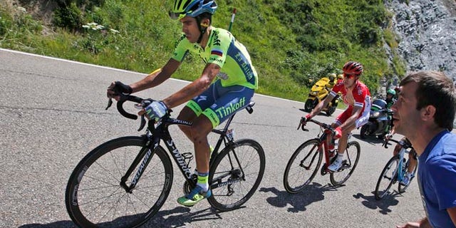 Spain's Alberto Contador, left, strains as he rides in the back of the pack with Franceâs Nicolas Edet, right, during the ninth stage of the Tour de France cycling race over 184.5 kilometers (114.3 miles) with start in Vielha Val d'Aran, Spain, and finish in Andorra Arcalis, Andorra, Sunday, July 10, 2016. (AP Photo/Christophe Ena)
