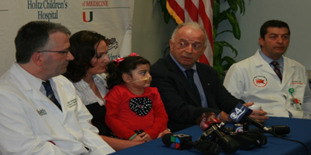 Angela Bushi sits with her mother, along with her surgeon Dr. Andreas Tzakis and the geneticist who diagnosed her, Dr. Olaf Bodamer, as they announce the success of their groundbreaking surgery.