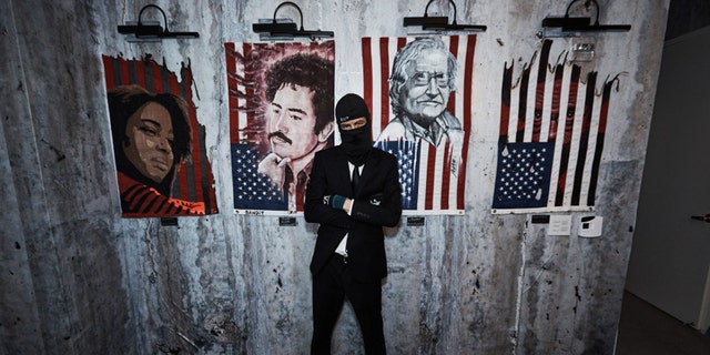 An artist poses in front of the artwork that will be sold next month.