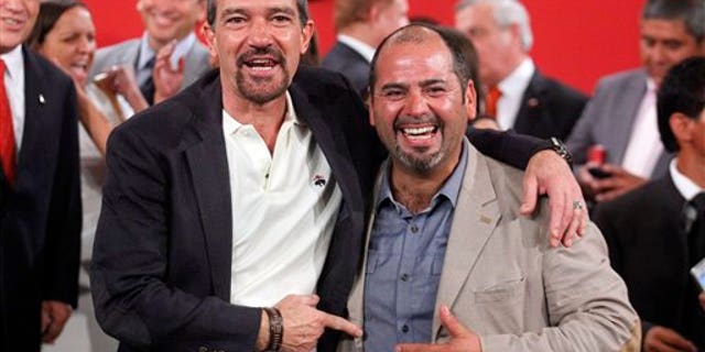 The Spanish actor, Antonio Banderas, left, poses for photographers next to Mario Sepulveda, in Santiago, Chile, Friday Jan. 31, 2014. Sepulveda was one of the 33 miners who was trapped in a mine cave-in in Chile's Atacama desert in 2010. The Spanish star will play Sepulveda, who known as "Super Mario," became the public face of the miners. (AP Photo/Luis Hidalgo)