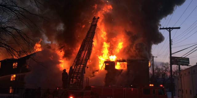 Firefighters battle a four-alarm fire at a three-story apartment complex Wednesday morning, March 5, 2014 on Detroit's west side. An official says the fire forced some people to jump to escape. (AP Photo/Detroit Free Press, Robert Allen)  DETROIT NEWS OUT;  NO SALES
