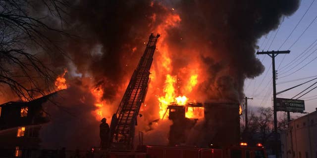 Firefighters battle a four-alarm fire at a three-story apartment complex Wednesday morning, March 5, 2014 on Detroit's west side. An official says the fire forced some people to jump to escape. (AP Photo/Detroit Free Press, Robert Allen) DETROIT NEWS OUT; NO SALES