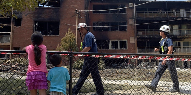 People view the scene of an apartment building fire in Silver Spring, Md., Thursday, Aug. 11, 2016.