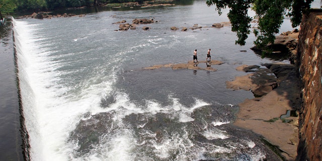 June 11, 2011: Men walk on the rocks in the Chattahoochee River below the City Mills dam near Columbus, Ga.