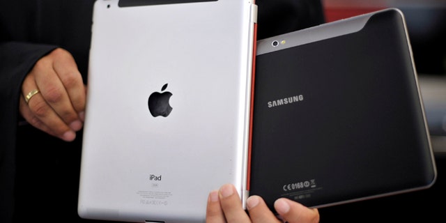 Aug. 25, 2011: An attorney holds an Apple iPad, left, and a Samsung Galaxy Tab 10.1 at the regional court in Duesseldorf, Germany.