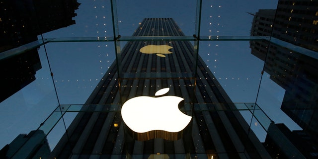 The Apple logo is illuminated in the entrance to the Fifth Avenue Apple store, in New York.