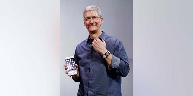 Apple CEO Tim Cook, holding an iPhone 6 Plus, discusses the new Apple Watch and iPhone 6s on Tuesday, Sept. 9, 2014.