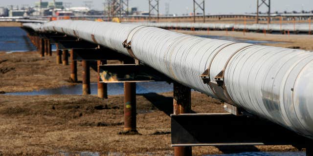 In this 2007 file photo, an oil transit pipeline runs across the tundra to flow station at the Prudhoe Bay oil field on Alaska's North Slope.