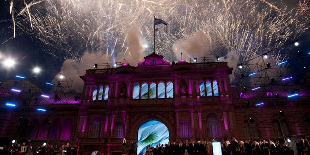 The government house is bathed in purple light as fireworks explode over a government rally in Buenos Aires, Argentina, Saturday, May 25, 2013. Cristina Fernandez's government and supporters are celebrating 10 years since she and her late husband Nestor Kirchner have held office, and the 203th anniversary of Argentina's May Revolution. (AP Photo/Natacha Pisarenko)