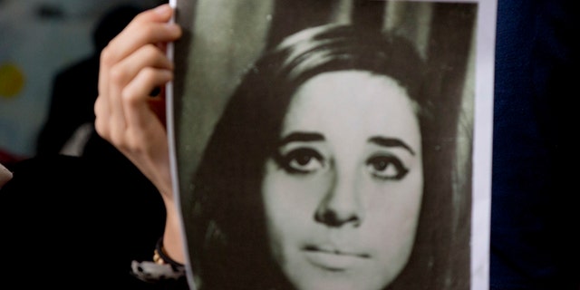 A woman holds an image of disappeared Ana Maria Lanzillotto during a press conference in Buenos Aires on Oct. 5, 2016.
