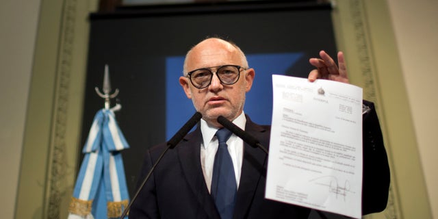 Argentina's Foreign Minister Hector Timmerman shows a letter that he said was sent in 2013 to Interpol's Secretary General Ronald Noble informing him of the agreement reached with Iran's government to investigate the 1994 bombing of the Argentine-Israeli Mutual Association that killed 85 people, in Buenos Aires, Argentina, Thursday, Jan. 15, 2015. Argentine prosecutor Alberto Nisman accused President Cristina Fernandez of reaching a secret deal with Iran to avoid punishing those responsible. (AP Photo/Rodrigo Abd)