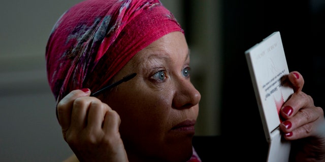 In this Nov. 8, 2013 photo, Gladys Szemis looks at herself in a mirror while putting on mascara during a "Look Good Feel Better" workshop that offers free lessons in makeup and skin care for women dealing with the physical and psychological trauma of cancer, in Buenos Aires, Argentina. These arenât the kind of makeup tips youâd find at a shopping mall lipstick stand. Techniques include covering up extremely dark circles, creating the impression of eyelashes, and drawing-on eyebrows where none remain. Lastly, women are taught how to properly wrap headscarves, which should be made of cotton rather than silk to avoid slipping off smooth pates. (AP Photo/Natacha Pisarenko)