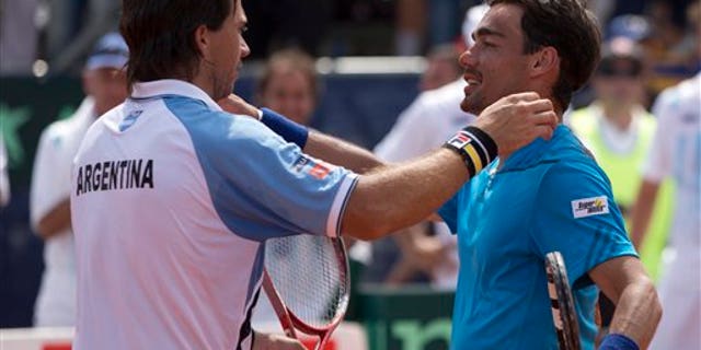 Argentina's Carlos Berlocq, left, and Italy's Fabio Fognini embrace at the end of their Davis Cup singles match, in Mar del Plata, Argentina, Sunday, Feb. 2, 2014. Fognini defeated Berlocq 7-6, 4-6, 6-1, 6-4 to give Italy a 3-1 victory. (AP Photo/Eduardo Di Baia)