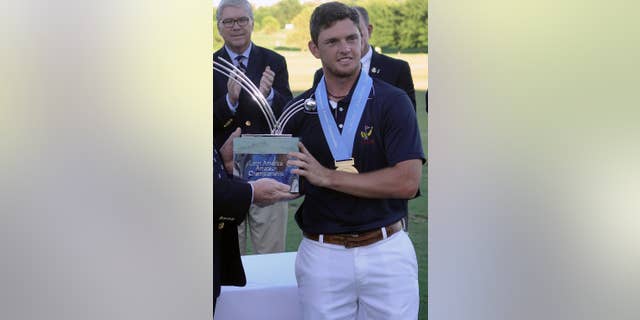 Chile’s Matias Dominguez receives the Latin American Amateur Championship trophy at the Pilar Golf Club in Buenos Aires, Argentina, Sunday Jan. 18, 2015. With a spot in the Masters riding on the outcome, Dominguez closed with a 1-under 71, winning the inaugural event and earning the right to be among Rory McIlroy, Tiger Woods and his golfing idol, Phil Mickelson, in April. (AP Photo/Emmanuel Fernandez)