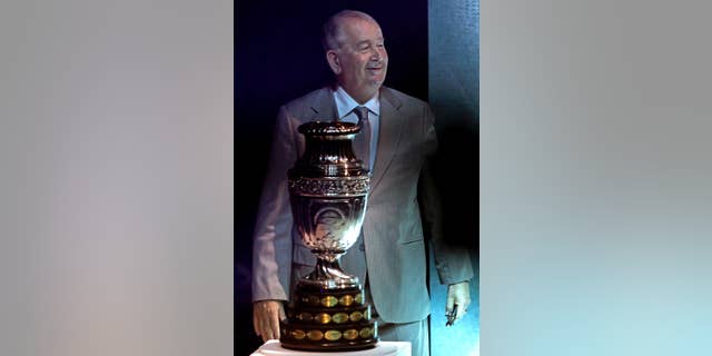 FILE - In this Nov. 11, 2010 file photo, Julio Grondona, president of the Argentine Football Association, stands behind the Copa America trophy during the draw of the groups' ceremony in La Plata, Argentina. Grondona was hospitalized on Wednesday, July 30, 2014, said national football authorities, who said he was "not feeing well." (AP Photo/Natacha Pisarenko, File)