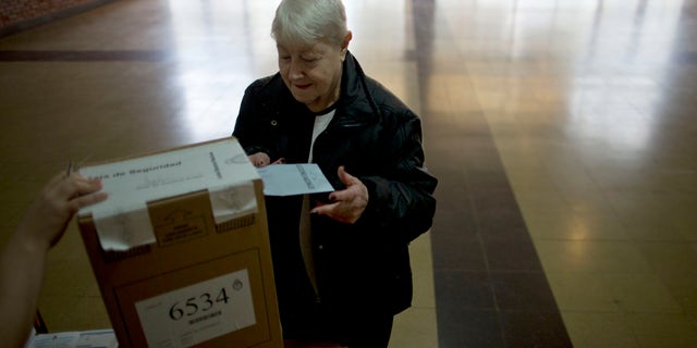 A woman casts her vote during open primary elections for presidential candidates in Buenos Aires, Argentina, Sunday, Aug. 9, 2015. The voters will decide presidential candidates in their respective parties ahead of the Oct. 25, 2015 general elections. (AP Photo/Natacha Pisarenko)