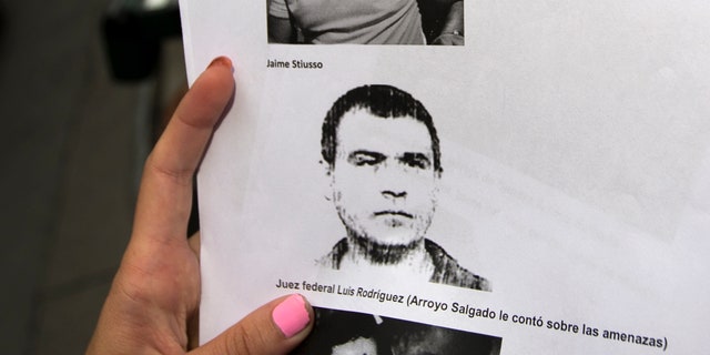 A reporter holds a picture of Antonio Stiuso, one of Argentina's most enigmatic spy chiefs.