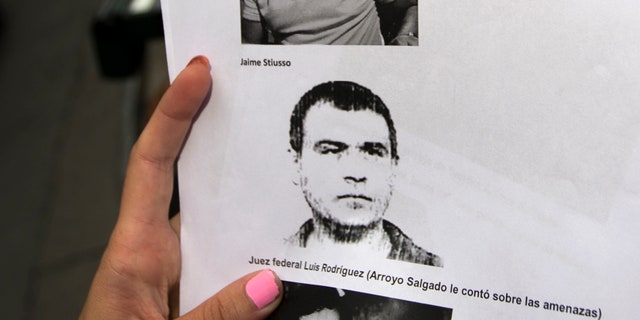 A reporter holds a picture of Antonio Stiuso, one of Argentina's most enigmatic spy chiefs.