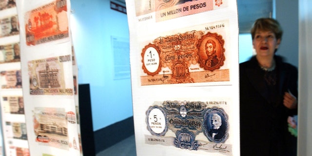 FILE - In this April, 28, 2005, file photo, a woman looks at old currency during the opening of the Foreign Debt Museum in Buenos Aires, Argentina. The museum, which is the world's first dedicated to a country's debt, opened nearly four years after Argentina staged the largest debt default in modern history. Argentine President Cristina Fernandez said Monday June 16, 2014 that Argentina can't comply with U.S. court orders to pay $1.5 billion to winners of a decade-long legal battle over defaulted debt, the position her country was left in Monday when the U.S. Supreme Court refused to hear her government's final appeal. (AP Photo/Natacha Pisarenko,File)