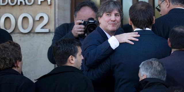 FILE - In this June 9, 2014 file photo, Argentina's Vice President Amado Boudou looks back as he enters a federal court in Buenos Aires, Argentina. The Vice President is back in court, this time over false data in the papers of an old car that he bought about 20 years ago. Boudou appeared before a federal judge Wednesday, July 23, 2014, and presented a written statement instead of speaking on his defense. Boudou is accused of transferring a Honda CRX automobile to his name irregularly in 2003. (AP Photo/Natacha Pisarenko, File)