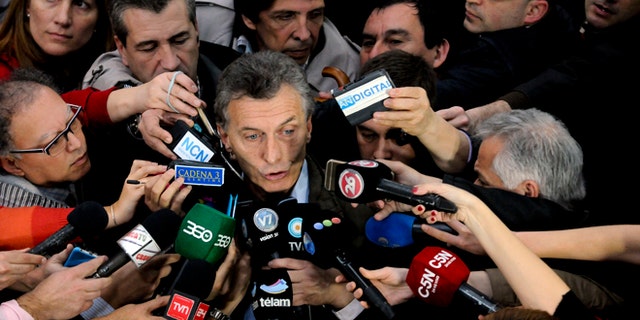 Outgoing mayor of Buenos Aires and presidential candidate Mauricio Macri, center, talks to the press after casting his vote in open primary elections in Buenos Aires, Argentina, Sunday, Aug. 9, 2015. The voters will decide Presidential candidates in their respective parties ahead of the Oct. 25, 2015 general elections. Macri is the top opposition candidate. (AP Photo/Maxi Failla)