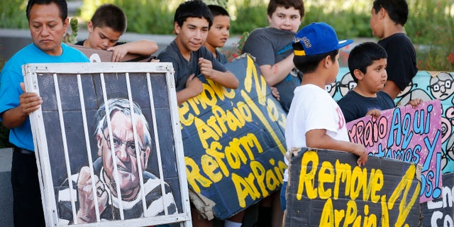 Protesters rally in front of Maricopa County Sheriff's Office Headquarters Wednesday, May 25, 2016, in Phoenix. Arizona taxpayers could be paying out to compensate hundreds of Latinos who were illegally detained when Sheriff Joe Arpaio rounded them up in past immigration patrols. (AP Photo/Ross D. Franklin)