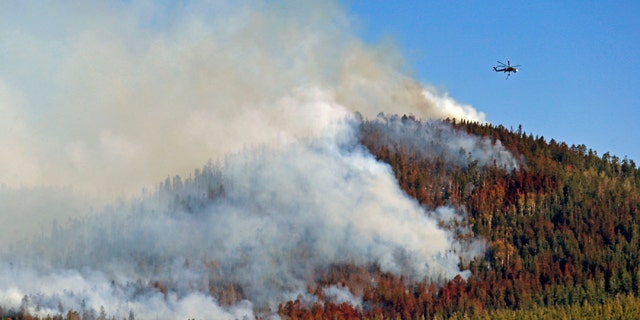 June 28, 2014: A helicopter hovers above the San Juan Fire in Vernon, Ariz. (AP Photo/The Arizona Republic, David Kadlubowski)