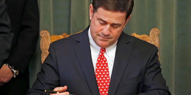 Feb. 24, 2015: Arizona Republican Gov. Doug Ducey signs the American Civics Act into law during a bill signing ceremony at the Capitol in Phoenix.
