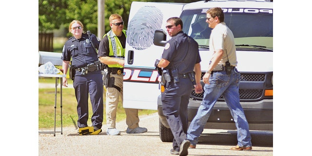 May 3, 2014: Jonesboro, Ark. police officers and crime scene analysts investigate a crime scene. Jonesboro Sgt. Doug Formon said a man and a 13-year-old girl were killed Saturday afternoon inside a residence in east Jonesboro, Arkansas. Four other people, including two boys, were injured and were taken to hospitals in Memphis, Tennessee. He said the children, ages 8 and 10, were transported in critical condition. (AP Photo/The Jonesboro Sun, Rob Holt)