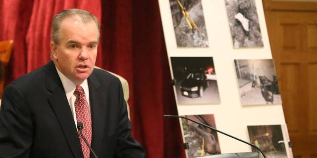 Acting Nassau County Police Commissioner Thomas Krumpter speaks with reporters on Aug. 27, 2015 in Mineola, N.Y., as he stands in front of a board showing crime scene photos of a botched burglary at an armored car company in Hicksville, N.Y. Authorities say a group of sophisticated burglars penetrated a vault of a Long Island armored car company and stole $1.8 million on Aug. 16, 2015, but were foiled by an alert police officer. (AP Photo/Mike Balsamo)