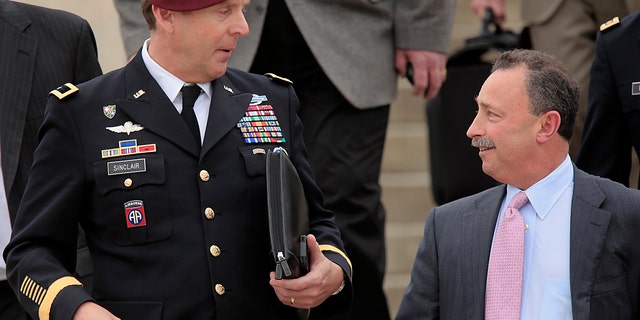 Brig. Gen. Jeffrey Sinclair, left, leaves court at Fort Bragg, N.C., Wednesday, March 19, 2014.
